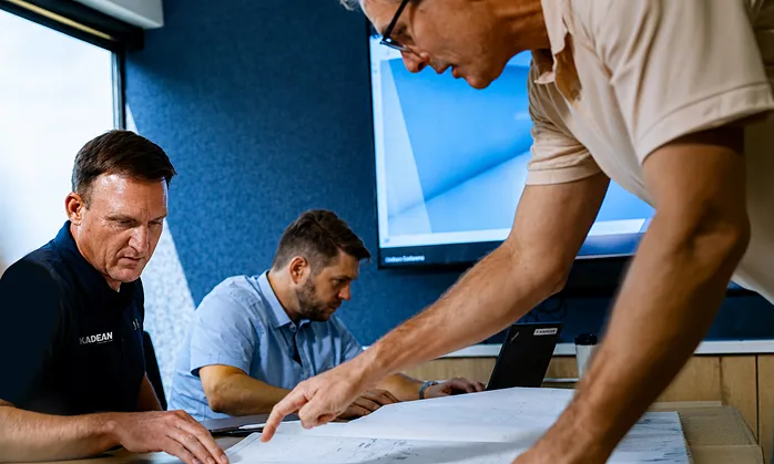 Group of men around schematics